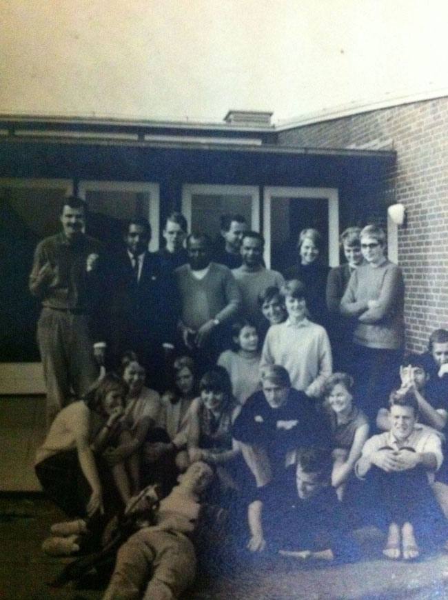 A large group of young people gathered outside a brick building